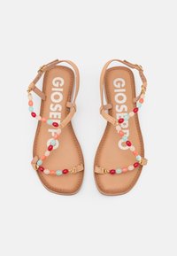 Hnědé ploché sandály s korálkovými popruhy v červené, růžové a modré barvě. Vybavené zlatým sponou a hladkým, texturovaným stélkou.
