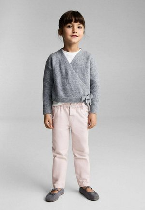 Gilet gris, chemise blanche, pantalon rose pâle et ballerines grises. Texture douce ; design décontracté avec un détail de nouage sur le côté.
