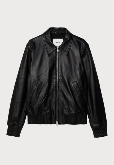 Melnas ādas jaka ar apkakles dekoltē, ar rāvējslēdzēju, ribotu apakšmalu un pieturām pie rokas, kā arī divām sānu kabatām. Gluda tekstūra, klasiskā dizaina.