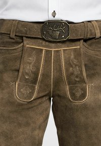 Lederhosen de ante marrón en ante con costuras decorativas, que cuentan con dos bolsillos frontales y una hebilla de cinturón metálica con un diseño de ciervo en relieve.