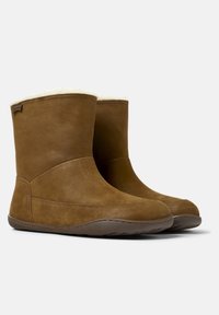 Hnědé semišové kotníkové boty s měkkým, krémově zbarveným kožíškem na vrchu a flexibilní gumovou podrážkou. Mají minimální švy a značení.