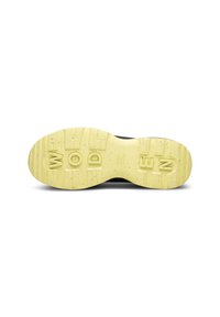 Suela negra de zapatilla con una suela de goma amarilla texturizada que presenta profundas hendiduras y letras en relieve que dicen "WOOD."