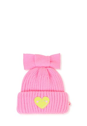 Roze gebreide muts met een grote strik bovenop en een geel hartpatch met een glimlachend gezicht op de omgeslagen rand.