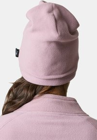 Pipo fleece berwarna pink lembut, dilengkapi dengan tepi lipat dan tag logo yang halus. Teksturnya halus dan hangat, cocok untuk cuaca dingin.