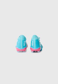 Bottes de football bleues au design épuré, avec une tige texturée et des accents roses sur la semelle. Construction légère pour des performances optimales.