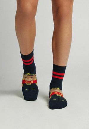 Calcetines navy con rayas rojas y diseño de soldado oso. Las características incluyen una ilustración detallada y una forma ajustada y cómoda. Material de mezcla de algodón.