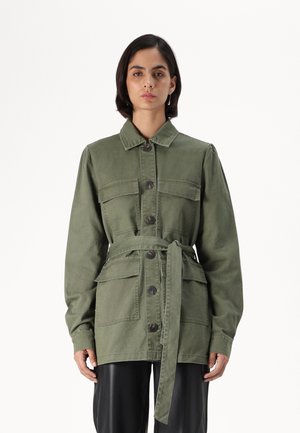 Veste ceinturée vert olive en coton avec quatre poches avant, fermeture à boutons et col. Tissu texturé avec une coupe décontractée.