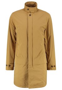 Tan vattentät jacka med kort krage, knappstängning fram, sidofickor och knäppta manschetter. Slät textur och rak skärning.