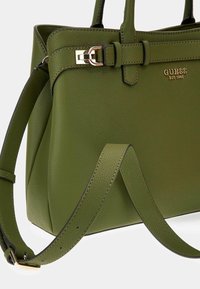 Bolso de piel verde con un diseño estructurado, textura suave, herrajes en tono dorado y una correa ajustable con detalle de hebilla.