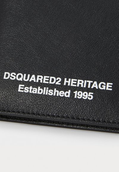 Sort tekstureret pung med præget hvid skrift: "DSQUARED2 HERITAGE Etableret 1995." Syede kanter med et slankt design.