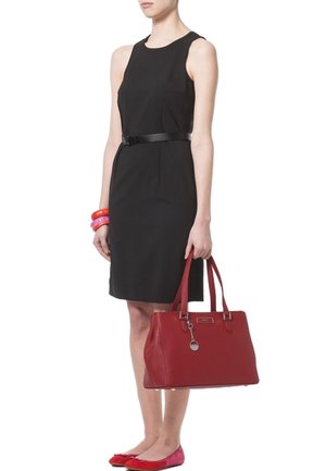 Czarna sukienka bez rękawów z dopasowaną talią, uzupełniona błyszczącym czarnym paskiem. Czerwona torebka i błyszczące czerwone baleriny dopełniają look.