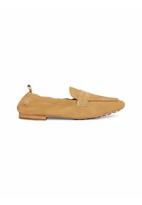 Mocassin femme en daim beige avec un petit talon, boucle décorative sur le dessus et petit détail de logo sur la languette du talon, présenté en vue latérale.