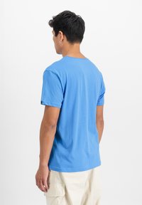 Modrá bavlněná tričko s kulatým výstřihem a krátkými rukávy, s volným střihem a malým akcentem na okraji rukávu.