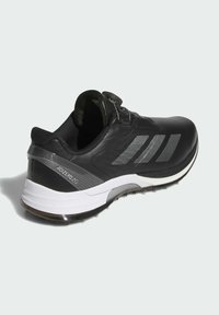 Black Adidas Adizero ZG athletic shoe with white and gray sole, three silver stripes on side, and dial-lace closure on the tongue.