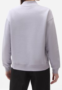 Ljuslila sweatshirt med hög krage, ribbad mudd och nederkant. Slät textur, avslappnad passform och sänkt axelsöm.