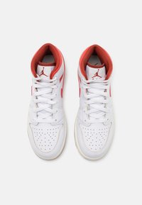 Sneakers din piele albă cu accente roșii, design înalt, cutie perforată pentru degete și șireturi. Prezintă logo-ul Jumpman pe limbă.