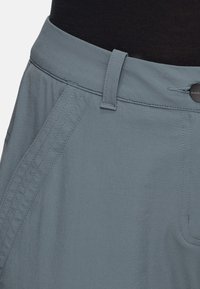 Lichtblauwe broek met een gladde textuur, voorzien van een riemlus, knoopsluiting en subtiele stiksels langs de zijnaad.