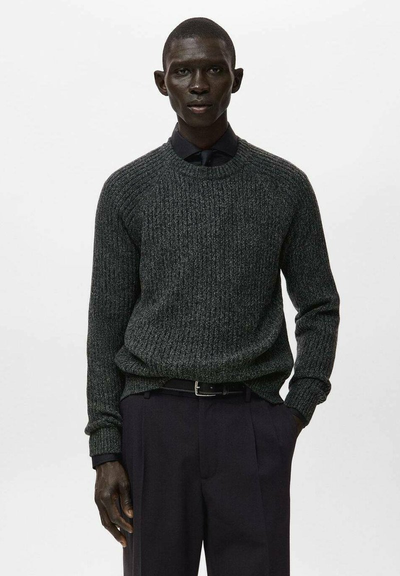 Maglione a coste grigio scuro con collo tondo, maniche lunghe, polsini aderenti, abbinato a pantaloni scuri e una camicia con colletto sotto.