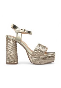 Sandales plateforme dorées avec un design tressé. Dot�ées d'une bride métallique à la cheville et d'un talon carré. Style à bout ouvert.