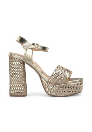 Gold platform sandals with a braided woven design. Features a metallic ankle strap and block heel. Open toe style.