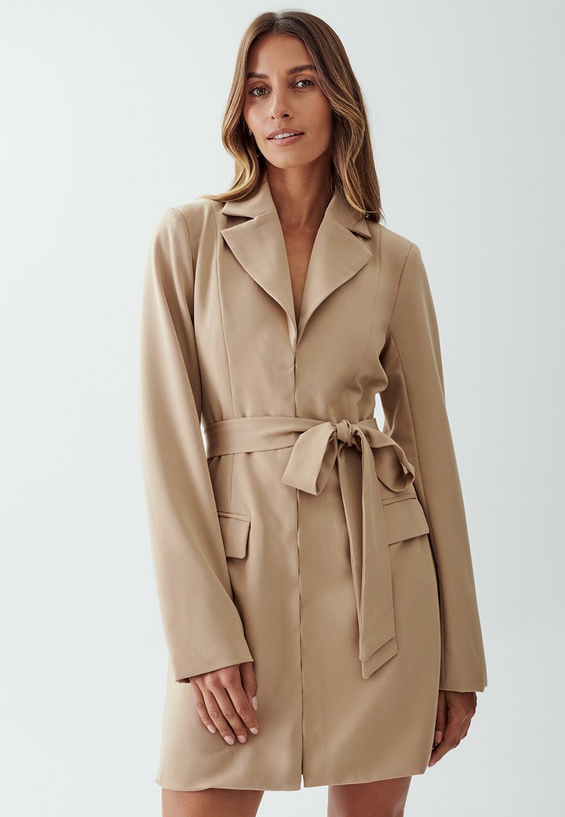 Beige dress coat with a belt, long sleeves, notch collar, and two front pockets. Made of smooth fabric with a tailored fit and knee-length design.