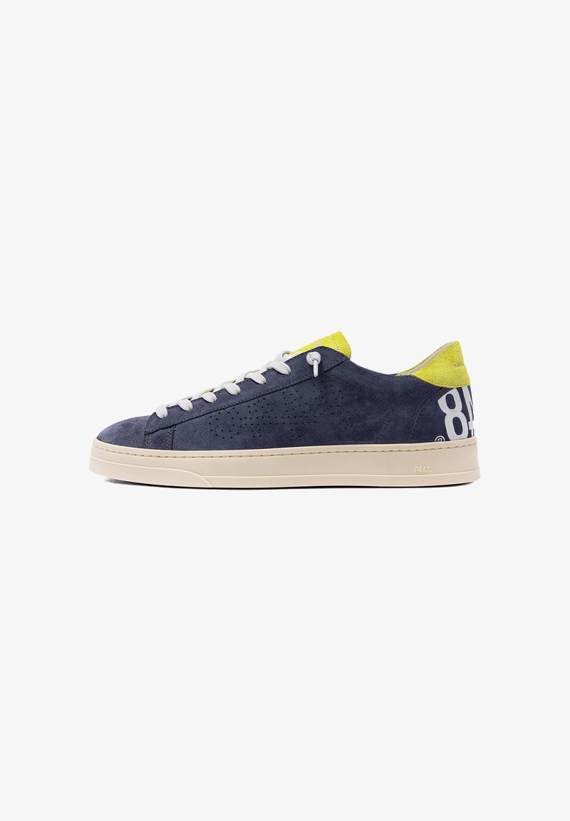 Baskets basses en daim bleu marine avec lacets blancs, semelle beige, accents jaunes au talon et à la languette, et grand numéro blanc imprimé sur le talon.