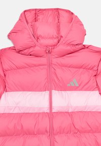 Rosa puffjacka med huva, med horisontella vita ränder, en framzipper och en subtil grå logotyp på bröstet. Slät, glänsande textur.