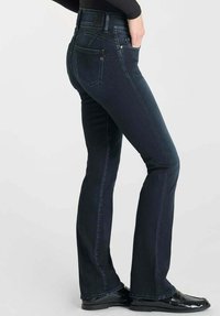 Donkerdenim jeans met een getailleerde silhoutte, een lichte flare aan de onderkant, een traditionele vijf-vakkenontwerp en gouden hardware accenten.