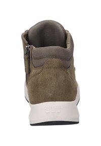 Brązowe zamszowe botki sięgające kostki z teksturowanym kołnierzem, zamkiem błyskawicznym oraz białą podeszwą z subtelnym logo na pięcie.