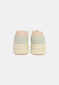 Scarpe sportive grigio scamosciato e superiore tessuto rosa chiaro con suola beige, caratterizzate da una forma arrotondata e un design minimale.