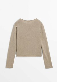 Pull en beige à manches longues en mailles texturées, avec un col rond et un ourlet court. Pas de fermetures ni de motifs visibles.