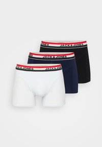 Trois paires de boxers pour hommes en blanc, marine et noir. Chacune présente une ceinture douce et élastique avec "JACK & JONES" en noir et rouge.