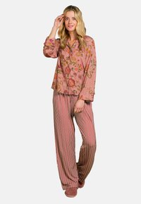 Pink floral-patterned long-sleeve shirt with loose striped pants in hues of red and beige. The fabric appears soft and lightweight.