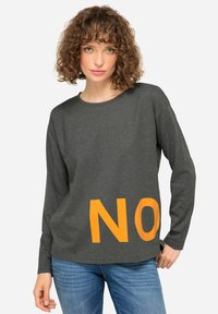 Maglietta grigia a maniche lunghe con scollo rotondo, caratterizzata da un grande design arancione con la scritta "NO" sul davanti. Tessuto in cotone morbido e casual.