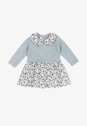 Baby-Kleid mit langen Ärmeln, hellgrauem gestricktem Oberteil, weißem Rock mit Blumenmuster und passendem Peter-Pan-Kragen mit blauen und roten Blumen.