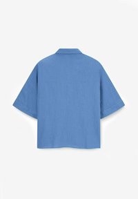 Blue linen shirt with a loose fit, short sleeves, and a classic collar. Textured surface and clean edges; no visible fastenings.