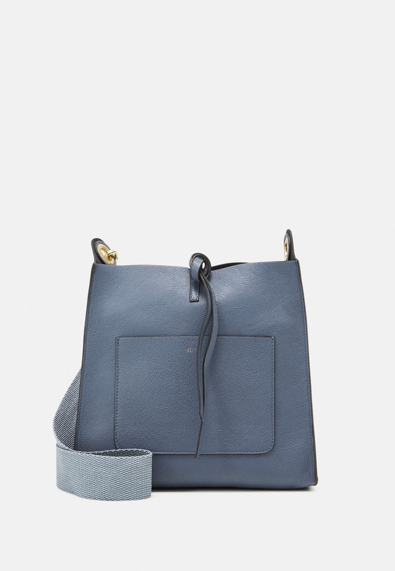 Blå läderhandväska med en strukturerad design, som har en framficka, en slät yta och ett vävt justerbart handtag. Guldiga detaljer.