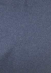 Temno modro pleteno blago z fino rebrasto teksturo, enakomerno tkano in dosledno barvo, primerno za oblačila ali oblazinjenje.