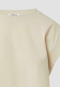 Beige katoenen t-shirt met een geribbelde ronde hals en korte mouwen. Glad textuur, minimalistisch ontwerp en subtiele branding zichtbaar.