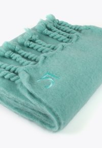 Couverture turquoise en tissu doux, dotée de franges tressées et d'un motif brodé avec le chiffre 5 dans une couleur assortie.
