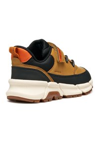 Sneaker in pelle marrone e tessuto nero con dettagli arancioni, fascia in velcro e suola bianca chunky con texture rigata e logo.