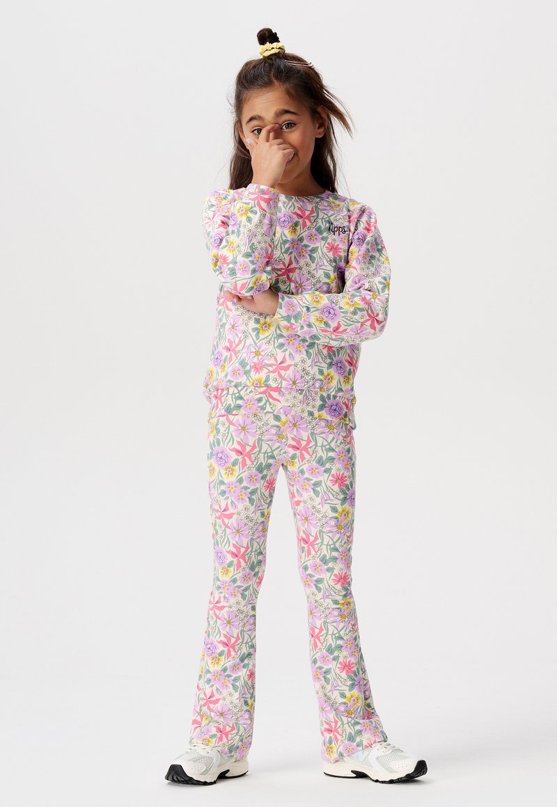 Ensemble sweat-shirt et pantalon à motif floral en rose, violet et vert, fabriqué à partir d'un tissu doux. Il dispose de manches longues et de jambes de pantalon évasées.