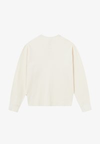 Camisa de manga larga color crema con un corte relajado, fabricada con un material texturizado, puños acanalados y un sutil detalle de costura a lo largo del dobladillo.
