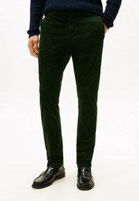 Donkergroene corduroybroek met een slim fit, voorzien van zijzakken, een soepele textuur en gecombineerd met zwarte instappers.