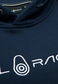 Námornícky modrá mikina z bavlněné směsi, vybavená kapucí na šňůrku a bílým vyšitým logem s okrouhlým designem. Texturovaná látka.