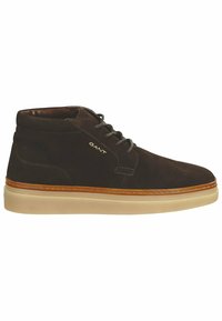 Braune Wildleder-Ankle-Boots mit Gummisohle, die über ein Schnürdesign, kontrastierende Nähte und ein goldenes Logo an der Seite verfügen.
