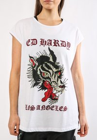 Camiseta blanca de manga corta con un gran gráfico de tigre bordado multicolor y texto "ED HARDY LOSANGELES" en rojo.