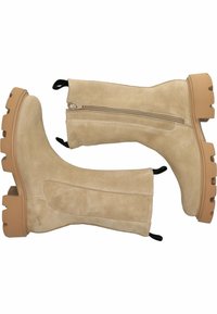 Botas de tobillo de ante beige con cremallera lateral y suela de goma texturizada. Cuenta con tiradores y un diseño de tacón cuadrado.