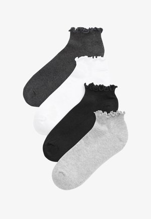 Quatre chaussettes basses aux chevilles en gris foncé, blanc, noir et gris clair, chacune avec un haut élastique à volants.