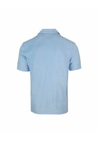 Polo di un blu chiaro, maniche corte, realizzato in tessuto morbido. Presenta un colletto classico e un logo discreto sulla manica sinistra.